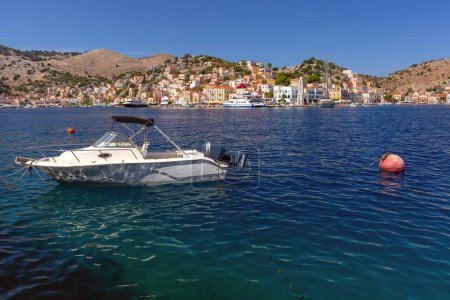 Serene harbor view with traditional fishing boat on Symi Island, Greece