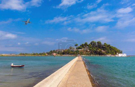 Flugzeug landet über dem Meer in Korfu, Griechenland, mit Menschen, die von einem Pier aus zusehen