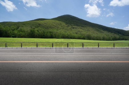 Téléchargez les photos : Vue latérale de la route asphaltée vide et de la montagne nuageuse - en image libre de droit