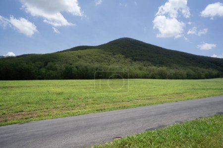Téléchargez les photos : Vue latérale de la route de campagne vide et montagne nuageuse - en image libre de droit