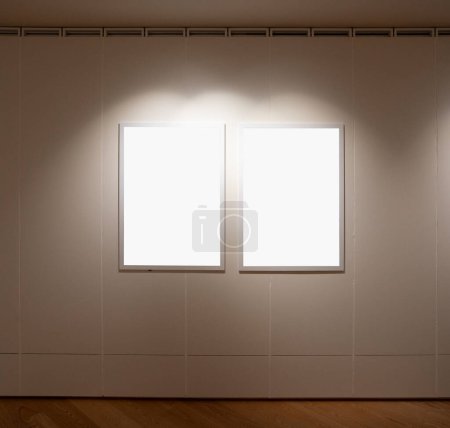 Téléchargez les photos : Vide deux cadres dans une pièce contre un mur blanc - en image libre de droit