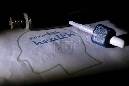 Foto de Concepto de salud mental y bienestar con un dibujo de un cerebro y un frasco de medicina - Imagen libre de derechos