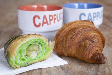 Photo for Morning awakening with cappuccino and half pistachio croissant - Royalty Free Image