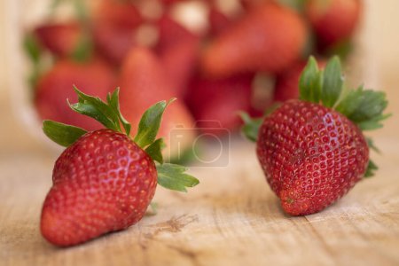 Téléchargez les photos : Deux fraises fraîches et mûres sur une table en bois - en image libre de droit