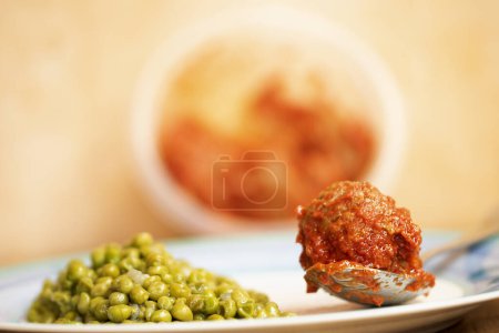 Téléchargez les photos : Boulette de viande en sauce avec un côté de petits pois - en image libre de droit