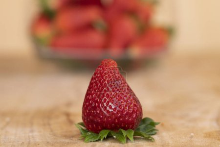 Téléchargez les photos : Fraise mûre devant un panier d'autres fraises - en image libre de droit