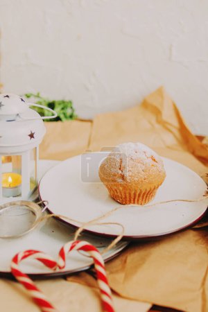 A Christmas cupcake on a plate sprinkled with powdered sugar