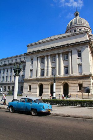 Téléchargez les photos : HAVANA, CUBA - 31 JANVIER 2011 : Les gens passent devant la vieille voiture classique américaine Chevrolet 150 garée à La Havane, Cuba. Cuba a l'un des plus bas taux de possession de voitures par habitant. - en image libre de droit