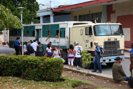 Téléchargez les photos : HOLGUIN, CUBA - 16 FÉVRIER 2011 : Des Cubains montent à bord d'un autobus urbain semi-remorque à Holguin. Cuba embargo commercial a abouti à une variété de solutions de fortune dans le transport. - en image libre de droit