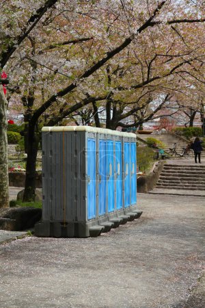 Photo for Cherry blossom season in Japan. Cherry blossoms in Sumida Park of Tokyo, Japan. Portable toilets. - Royalty Free Image