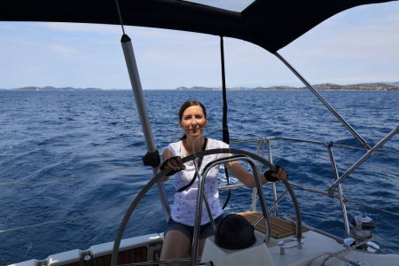 Foto de Mujer al mando de un yate de vela en Croacia. Verano vela aventura. - Imagen libre de derechos