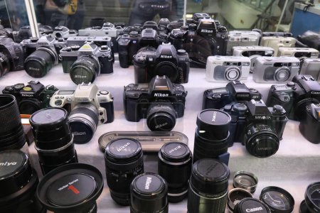 Foto de SEOUL, COREA DEL SUR - 7 DE ABRIL DE 2023: Cámaras y lentes SLR de película clásica en una ventana de una tienda de equipos de fotografía de segunda mano en Seúl. - Imagen libre de derechos