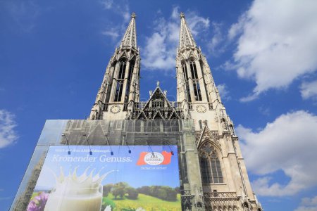 Photo for VIENNA, AUSTRIA - SEPTEMBER 5, 2011: Advertisement printed on protective net of scaffolding during renovation works of Votive Church in Vienna. It helped covering the cost of restoration. - Royalty Free Image