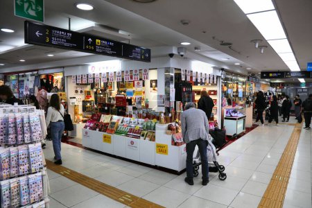 Foto de SEÚL, COREA DEL SUR - 5 DE ABRIL DE 2023: La gente visita la tienda de recuerdos en Myeongdong Underground Shopping Center en las pasarelas subterráneas de la estación de Myeongdong. - Imagen libre de derechos