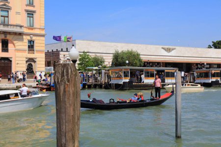 Téléchargez les photos : VENISE, ITALIE - 21 MAI 2023 : Les gens prennent un bateau traditionnel en gondole devant la gare principale Venezia Santa Lucia à Venise, Italie. - en image libre de droit