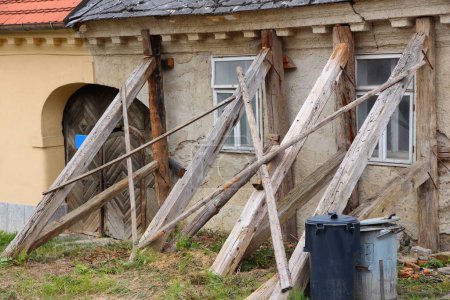 Soportes temporales de viga de madera que sostienen una casa en Koszeg, Hungría. Vigas de madera que impiden el colapso estructural del edificio antiguo.