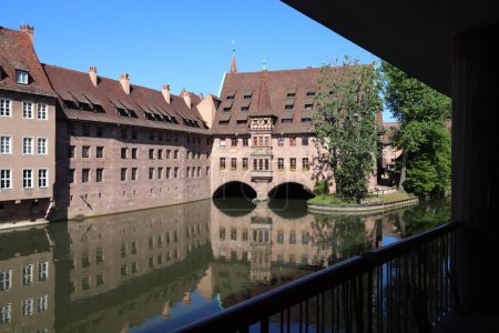 Nuremberg landmark in Germany. Holy Spirit Hospital (Heilig-Geist-Spital) on river Pegnitz. Medieval landmark.