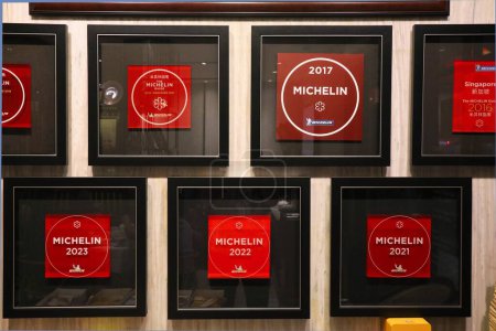 Foto de SINGAPUR CIUDAD, SINGAPUR - 11 DE MARZO DE 2024: Múltiples premios Michelin Star exhibidos dentro del restaurante Putien en la ciudad de Singapur. - Imagen libre de derechos