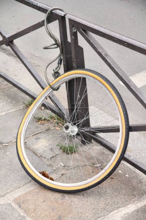 Gestohlenes Fahrrad - Vorderrad an Geländer einer Straße in Paris, Frankreich.