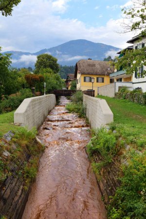 Téléchargez les photos : Ruisseau d'eaux pluviales boueuses se jetant dans Millstatter See (lac Millstatt) en Carinthie, Autriche. - en image libre de droit