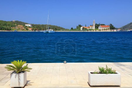 Waterfront view with Sv Jeronim church (St Jerome) in Vis island, Croatia. Focus on plant pots.