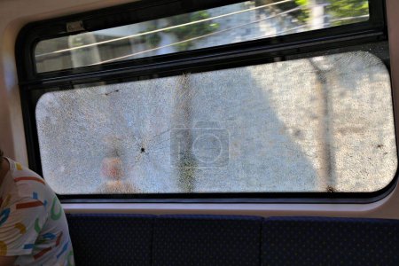 Damaged train window in Kuala Lumpur, Malaysia. Common public transportation vandalism problem in Malaysia.