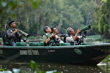 Foto de SUKAU, MALASIA - 7 DE MARZO DE 2024: Los turistas toman parte en una excursión en bote por el río Kinabatangan en Sukau, en la División Sandakan, en el noreste de Sabah, en la isla de Borneo, Malasia. - Imagen libre de derechos