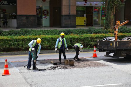 Photo for SINGAPORE CITY, SINGAPORE - MARCH 11, 2024: Road maintenance workers drill the street surface in Rochor area, Singapore City. - Royalty Free Image