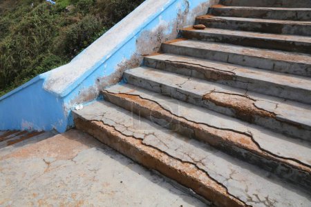 Weather damage of concrete. Flaking concrete on beach stairs. Problem of Mexico.