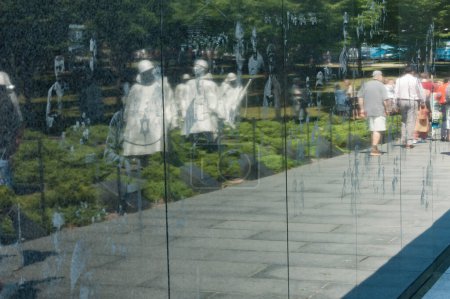 Foto de Reflexiones de las esculturas de la Guerra de Corea y turistas en la pared mural de granito. El trabajo bidimensional se encuentra en el National Mall and Memorial Parks de Washington, DC. - Imagen libre de derechos