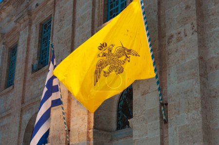 Foto de Bandera bizantina con águila de dos cabezas con bandera azul nacional en la iglesia ortodoxa griega, Chania, Grecia - Imagen libre de derechos