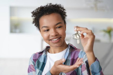 Photo for Smiling young biracial girl tenant shows house key to new home, first apartment. Happy mixed race teen lady houseowner renter tenant holding bunch of keys. Real estate rental service advertisement. - Royalty Free Image