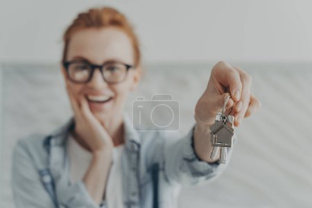 Photo for Happy female owner of new flat shows keys being glad renter or buyer. Client of real estate agency demonstrates she is houseowner. Focus on bunch of keys. Welcome to new home. Rent realty concept - Royalty Free Image