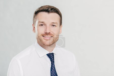 Photo for Self confident handsome unshaven male employee, wears white shirt and tie, rejoices signing agreement between business partners, isolated over white background. Confident man director indoor - Royalty Free Image