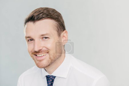 Photo for Positive young unshaven male entrepreneur has pleasant smile, dressed in elegant clothes, rejoices successful meeting with colleagues, discuss their business plans, isolated over white background - Royalty Free Image