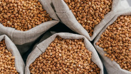 Comida y concepto de alimentación saludable. Primer plano de trigo sarraceno crudo en sacos. Nutrir. Secar los cereales sanos. Ingredientes. Vista superior
