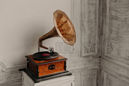 Music device. Old gramophone with plate or vinyl disk on wooden box. Antique brass record player. Gramophone with horn speaker. Retro entertainment concept.