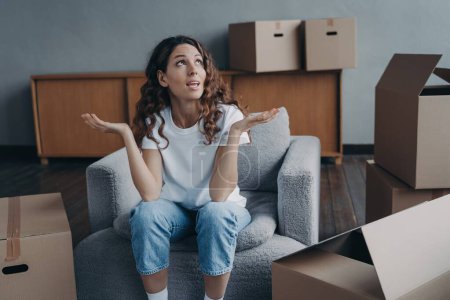 Photo for Tired divorced woman sitting with boxes, expressing frustration after packing for relocation. Difficult moving day, divorce concept. - Royalty Free Image