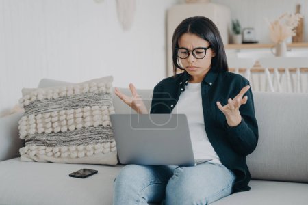 Photo for Angry woman struggles with laptop, forgets password. Unhappy, reads bad news, weak wifi, slow internet. - Royalty Free Image