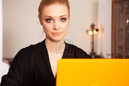 Téléchargez les photos : Attrayant yopung jolie blonde étudiante fille en chemise blach de travail sur ordinateur - en image libre de droit