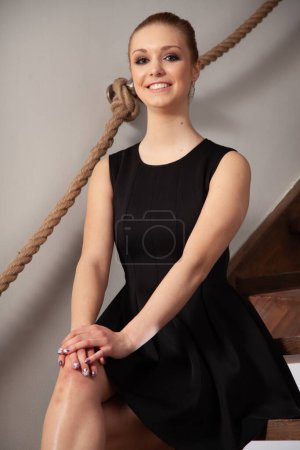 Téléchargez les photos : Jolie jeune adulte attrayant et beauté brunette femme assise sur des escaliers en bois à la maison - en image libre de droit