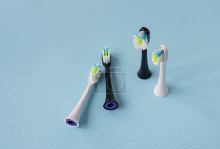 Foto de Cepillo de dientes eléctrico moderno de pie sobre un fondo azul, tiempo para cambiar el cepillo viejo y nuevo cabezal de cepillo. Producto controlado para el cuidado diario de la cavidad oral. Concepto de higiene - Imagen libre de derechos