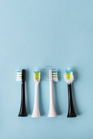 Foto de Cepillo de dientes eléctrico moderno sobre un fondo azul, es hora de cambiar el cepillo - accesorio de cepillo viejo y nuevo. Concepto de higiene para el cuidado bucal diario - Imagen libre de derechos