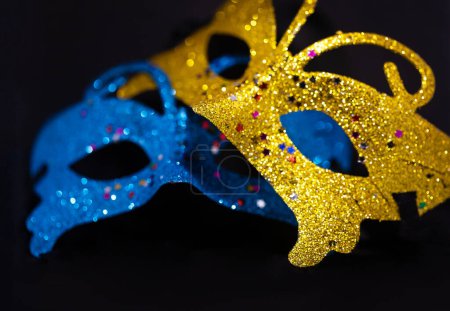 Foto de Máscara veneciana brillante amarilla y azul aislada sobre fondo negro. Fiesta de Año Nuevo, esconde tu cara. Primer plano - Imagen libre de derechos