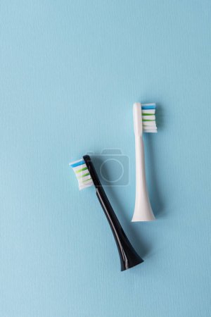 Foto de Cepillo de dientes eléctrico moderno sobre fondo azul. Concepto de higiene para el cuidado bucal diario - Imagen libre de derechos