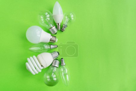 Photo for A set of different types of LED lamps isolated on a green background. Energy-saving lamps - Royalty Free Image