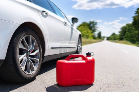 Foto de Depósito de coche vacío de una lata roja en el lado de la carretera. Problema de combustible. Lugar para una inscripción - Imagen libre de derechos