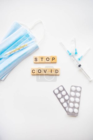 Photo for Stop coronavirus inscription. Preparation for vaccination against covid-19. Syringe, vaccine, pills, medical mask - Royalty Free Image
