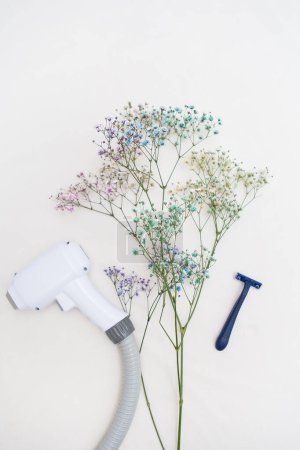 Eine Laser-Haarentfernungsmaschine und ein Rasiermesser stehen zarten Blumen auf hellem Hintergrund gegenüber, die den Kontrast zwischen moderner Technologie und der üblichen Methode der Haarentfernung symbolisieren.