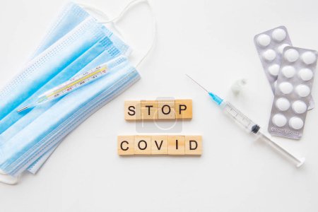 Photo for Stop coronavirus inscription. Preparing for vaccination against covid. Syringe, vaccine, pills, medical mask. A new strain of the virus - Royalty Free Image